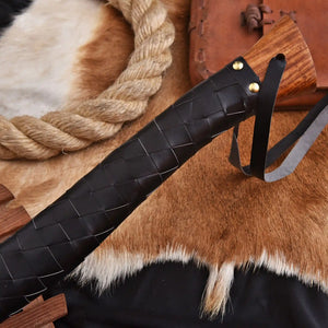Wooden handle of axe wrapped with black leather strap